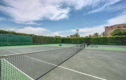 塞拉莱塞拉莱皇冠假日酒店度假村的一个带网和长凳的网球场