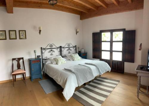 Villanueva de PríaLa Ribera de Pría的一间卧室配有一张床、一张桌子和一个窗户。