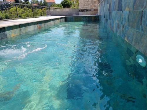 特雷比涅Vila Hercegovka的墙上充满蓝色水的游泳池