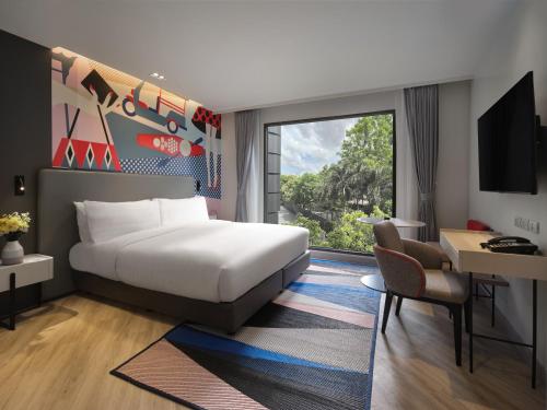 曼谷曼谷素坤逸奥克伍德华庭工作室酒店的配有一张床、一张书桌和一扇窗户的酒店客房