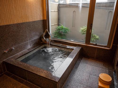 铃鹿市Hotel Castle Inn Suzuka Chuo的一间带喷泉浴缸的浴室