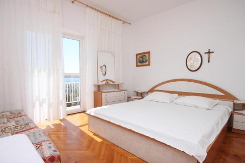 库斯提奇Rooms by the sea Kustici, Pag - 6288的白色的卧室设有一张大床和一个窗户