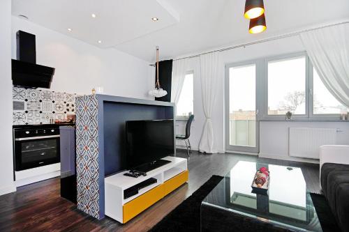 什切青JTB Nautica Aparthotel的客厅配有平面电视和沙发。