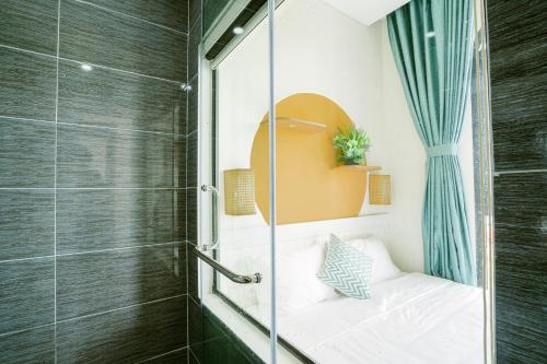 富国Mộc Homestay GrandWorld Phú Quốc的浴室设有玻璃淋浴间和一张床