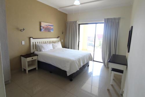 乌旺戈海滩Saints View Resort Unit 8的一间卧室配有一张床、一个窗口和一张书桌
