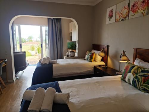 德班Africatamna Self Catering House的酒店客房设有两张床和窗户。