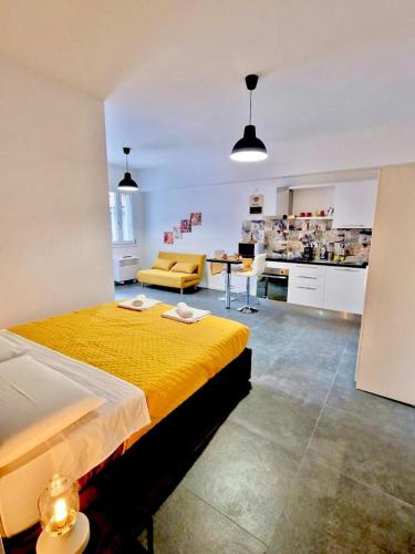 博洛尼亚FriendlyHouse的一间带一张黄色大床的卧室和一间厨房