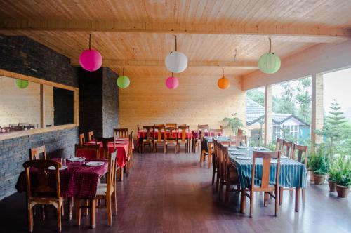 ShogiOakwood Hamlet Resort的用餐室配有桌椅和色彩缤纷的灯光