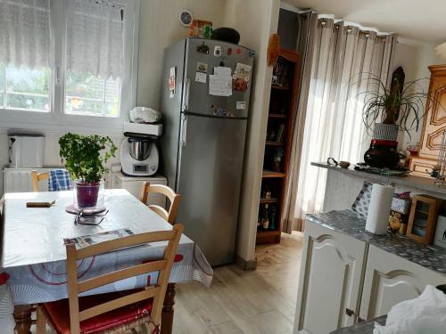SpayMaison proche circuit 24h du mans的厨房配有不锈钢冰箱和桌子
