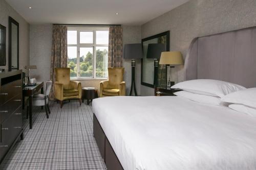 斯拉利Slaley Hall Hotel, Spa & Golf Resort的酒店客房设有一张大床和一张书桌。