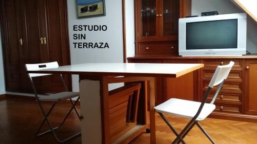 比韦罗Rua Granxas, n 13, Piso con terraza o Estudio sin terraza的一张桌子、两把椅子和一台电视机
