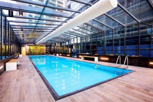 墨尔本Modern 3 Bedroom 2 Bathroom Apt Southbank的一座带玻璃天花板的大型游泳池