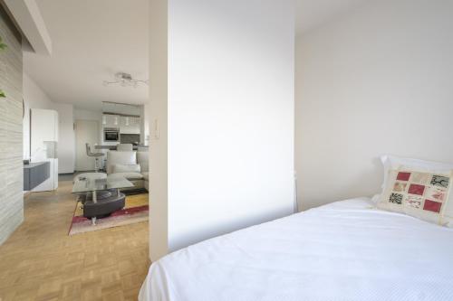 布鲁塞尔Nice studio with big terrace的一间带白色床的卧室和一间客厅