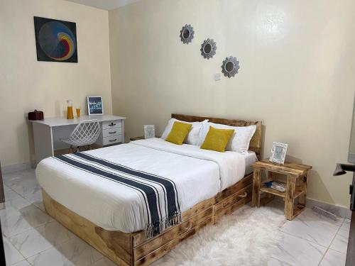 尼耶利Ruby Modern Homes-1br-Nyeri, King'ong'o-Marriott的一间卧室配有一张带黄色枕头的大型木制床。