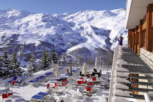 里蒙纽耶Belambra Clubs Les Menuires - Neige Et Ciel的站在一个俯瞰白雪 ⁇ 的山的阳台上的女人