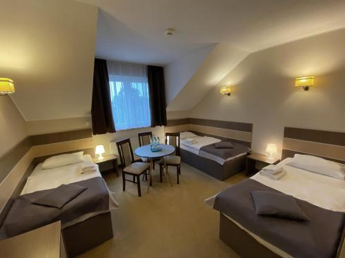 弗罗茨瓦夫Hotel Sleep Wrocław的一间设有两张床和一张桌子及椅子的房间