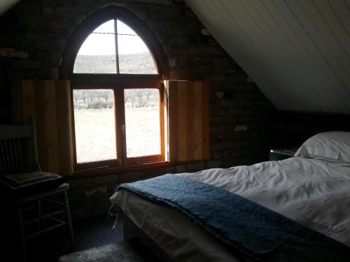 Nieu-BethesdaDie Kapokbosskuur的一间卧室设有一张床和一个大窗户