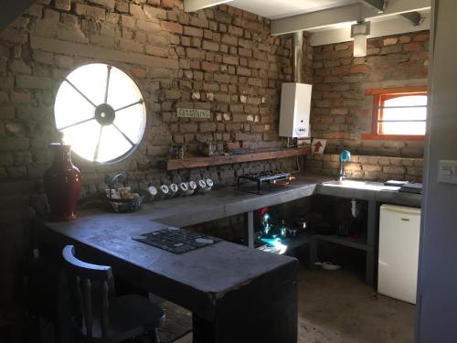 Nieu-BethesdaDie Kapokbosskuur的厨房配有桌子和大窗户