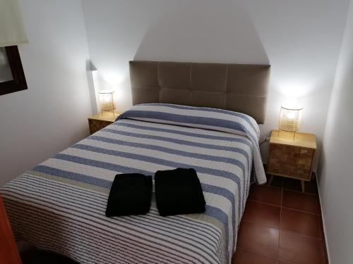 阿里纳加Apartamentos Risco Verde的一间卧室配有一张带两个黑色枕头的床