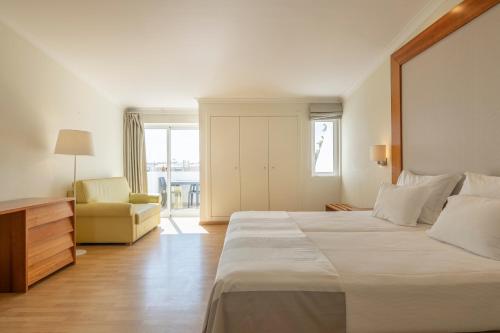 拉戈阿拉戈阿度假屋的酒店客房带一张大床和一把椅子