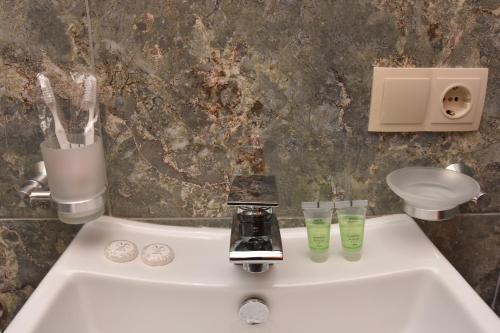 祖格迪迪Hotel & Restaurant Sokhumi的浴室水槽配有两杯玻璃和水龙头