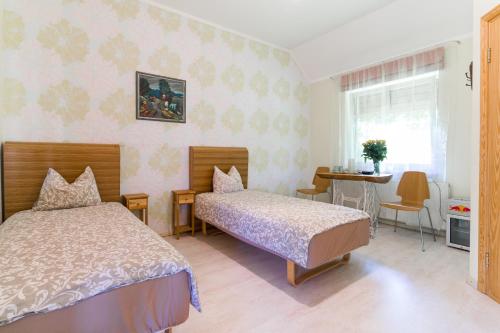 Medemciems塞帕斯旅舍的一间卧室配有两张床、一张桌子和一张桌子