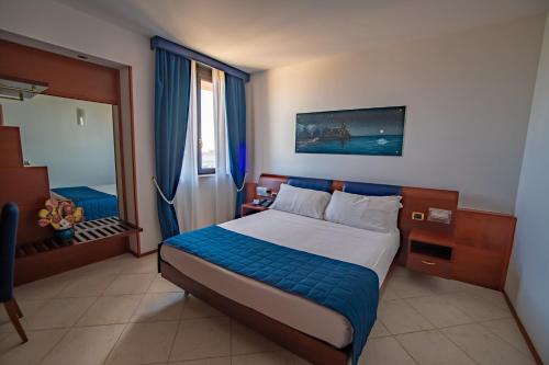 布林迪西Best Western Hotel Nettuno的一间卧室设有一张大床和一个窗户。