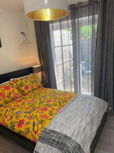 Golden ValleyA Room at The Oaks的一间卧室配有一张带黄色毯子和窗户的床