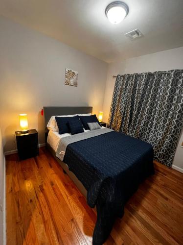 纽瓦克SPRINGVIEW HOMES 12MINS FROM EWR & 3 MINS FROM UNIVERSITY HOSPITAL的一间卧室配有一张带蓝色床单的床和一扇窗户。