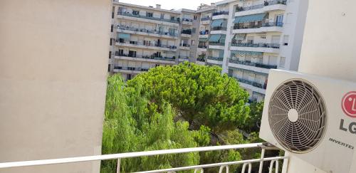 尼斯Nice appartement Avenue des Fleurs的大楼一侧带风扇的阳台