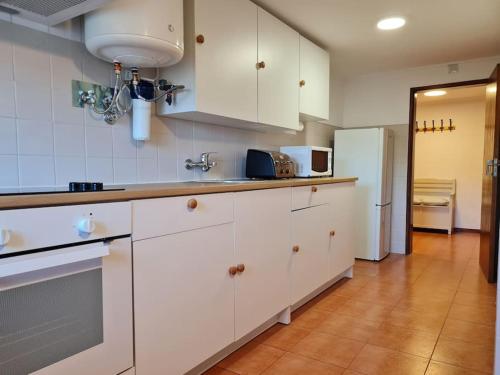 辛特拉Alojamento 3 vistas的厨房配有白色橱柜和冰箱。