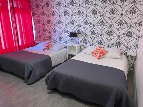 普瓦捷奥夏蓬分酒店的配有粉红色和紫色壁纸的客房内的两张床