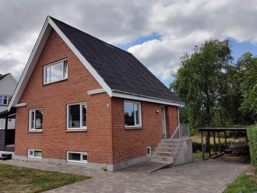 约灵Bjergby Guesthouse的红砖房子,有 ⁇ 帽屋顶
