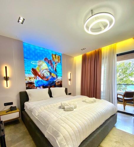 乌尔齐尼Marinus Hotel的卧室配有一张大床,墙上挂有绘画作品