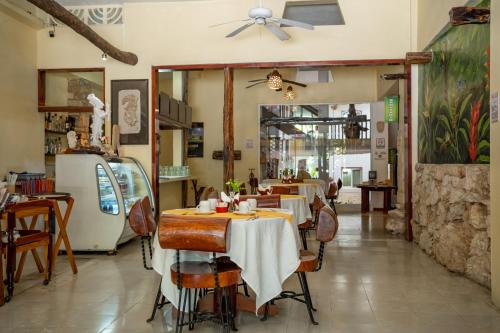 帕伦克Hotel - Museo Xibalba的餐厅配有桌椅和吊扇