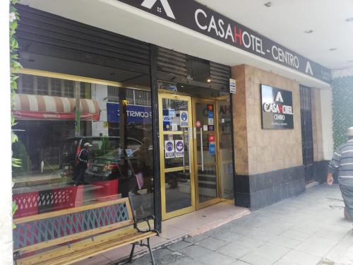 万卡约CasaHotel Centro - Huancayo的前面的商店,前面有长凳