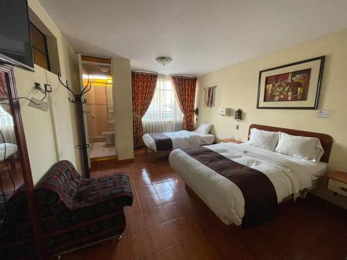 万卡约CasaHotel Centro - Huancayo的配有一张床和一把椅子的酒店客房
