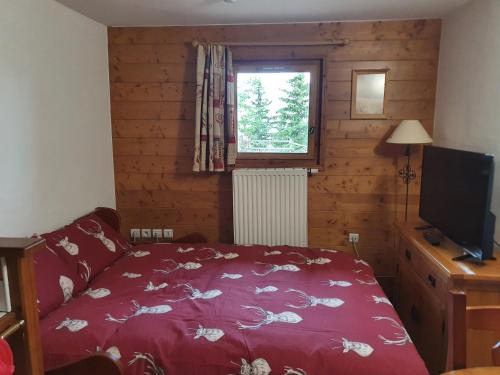 阿克1800Premium Les Alpages de Chantel的一间卧室配有红色的床和电视