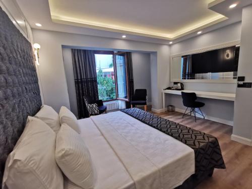 伊斯坦布尔Luxx Garden Hotel的卧室配有一张白色大床和一张书桌