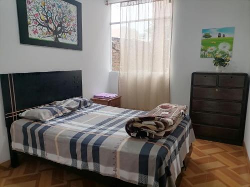 齐克拉约Departamento - Los Mitos del Parque M2的一间卧室配有一张带蓝白色毯子的床