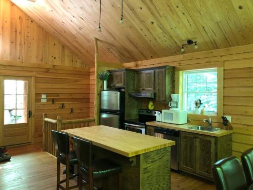 Val-des-LacsQuiet, cozy and comfortable chalet的厨房设有木墙和木制天花板。