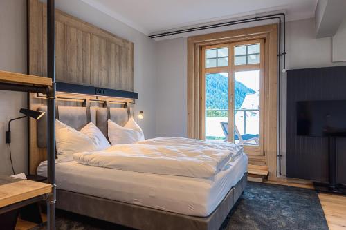 达沃斯ALPINE INN Davos的一间卧室配有一张大床和电视