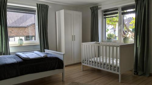 许特根瓦尔德Eifel-Ferienhaus Landblick的带窗户的客房内的婴儿床