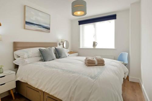 FelphamSeaside Annexe的卧室配有一张带白色床单的大床和窗户。