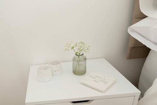 FelphamSeaside Annexe的一张白色的桌子,上面有花瓶