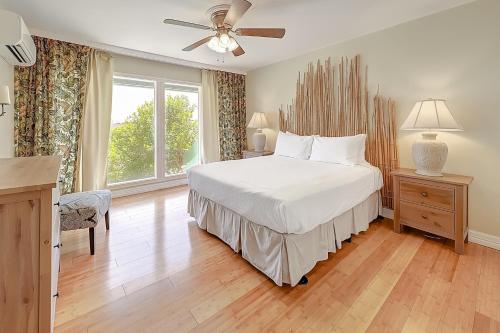 帕德雷岛Aloha Condo的卧室配有白色的床和吊扇