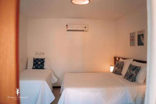 阿拉亚尔达茹达Cores do Arraial Residence Hotel的白色墙壁客房的两张床