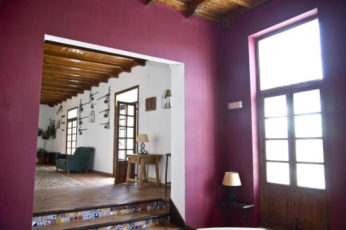 普里埃格·德·科尔多巴Villa Turística de Priego的一间拥有紫色墙壁、门和桌子的房间