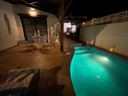 大塔拉哈尔Casa Mararía的游泳池在晚上配有桌椅