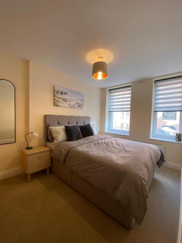 伯恩茅斯1 bedroom apartment in the heart of Bournemouth的一间卧室设有一张大床和两个窗户。